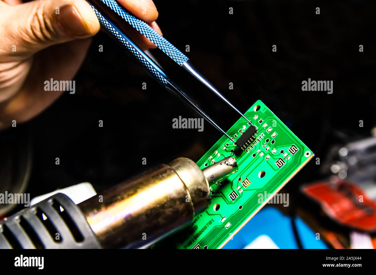 Technical support worker drops the fee PCB. Soldering iron. Tweezers Stock Photo