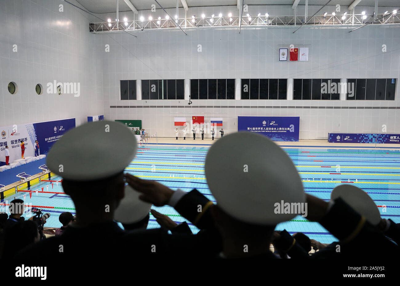 (191021) -- WUHAN, Oct. 21, 2019 (Xinhua) -- Soldiers salute during the awarding ceremony of the men's 100m rescue medley final of lifesaving at the 7th CISM Military World Games in Wuhan, capital of central China's Hubei Province, Oct. 21, 2019. (Xinhua/Wang Lili) Stock Photo