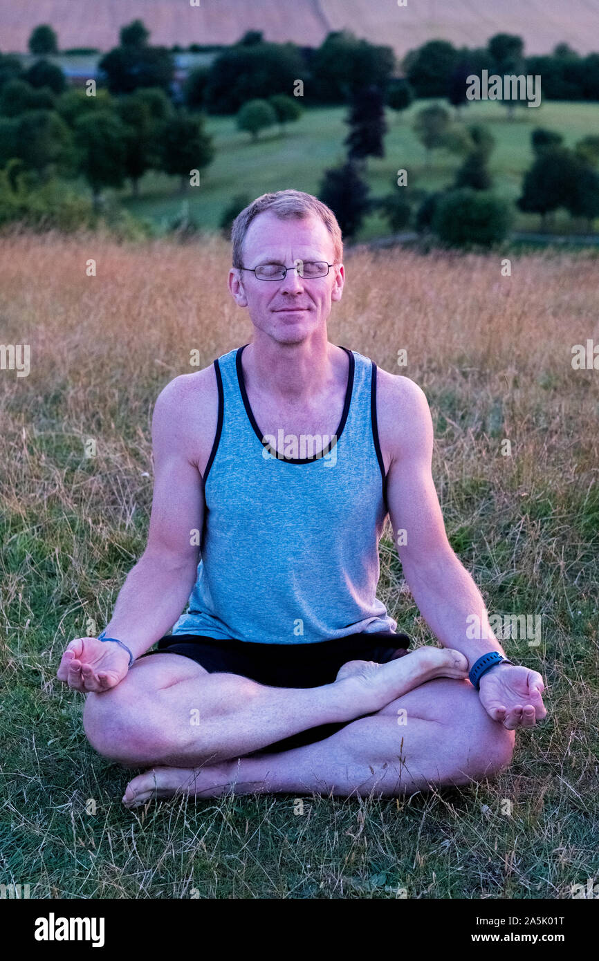 Man taking part in a yoga class on a hillside Stock Photo Alamy