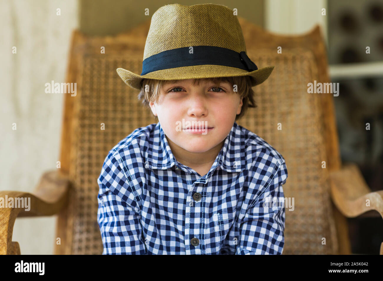 portrait of 6 year old boy sitting in wicker chair Stock Photo Alamy