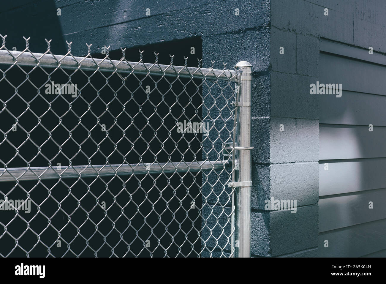 Chainlink fence over building doorway, graffiti spray paint on urban