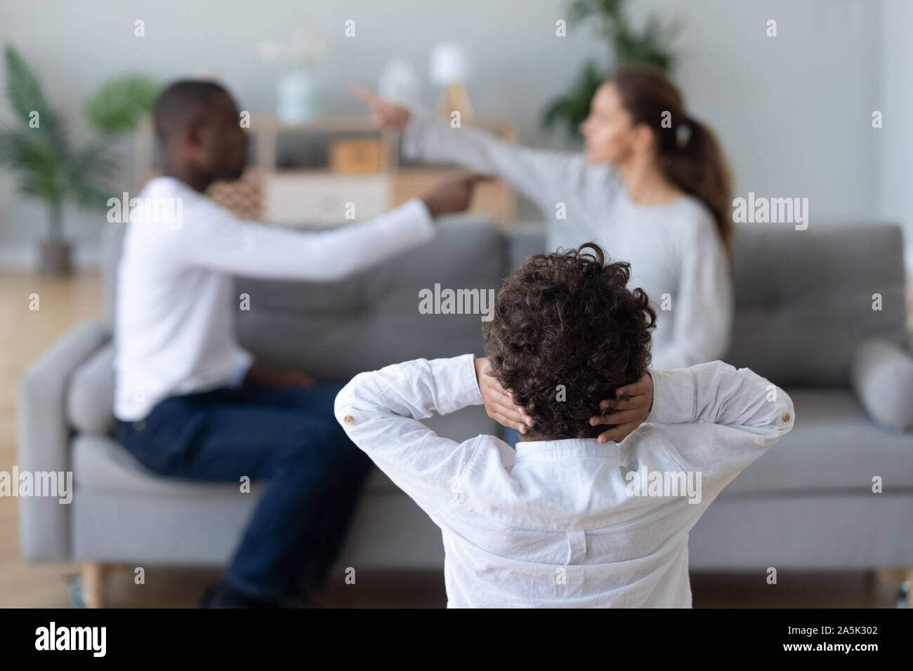 Little child cover ears avoiding parents fight at home Stock Photo Alamy