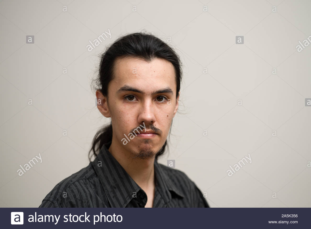 Long Haired Man With A Mustache And Ponytail Wearing A Black