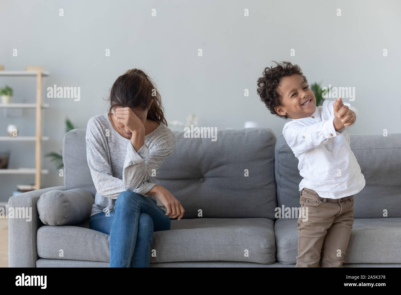 Stressed mother get annoyed by naughty little son Stock Photo