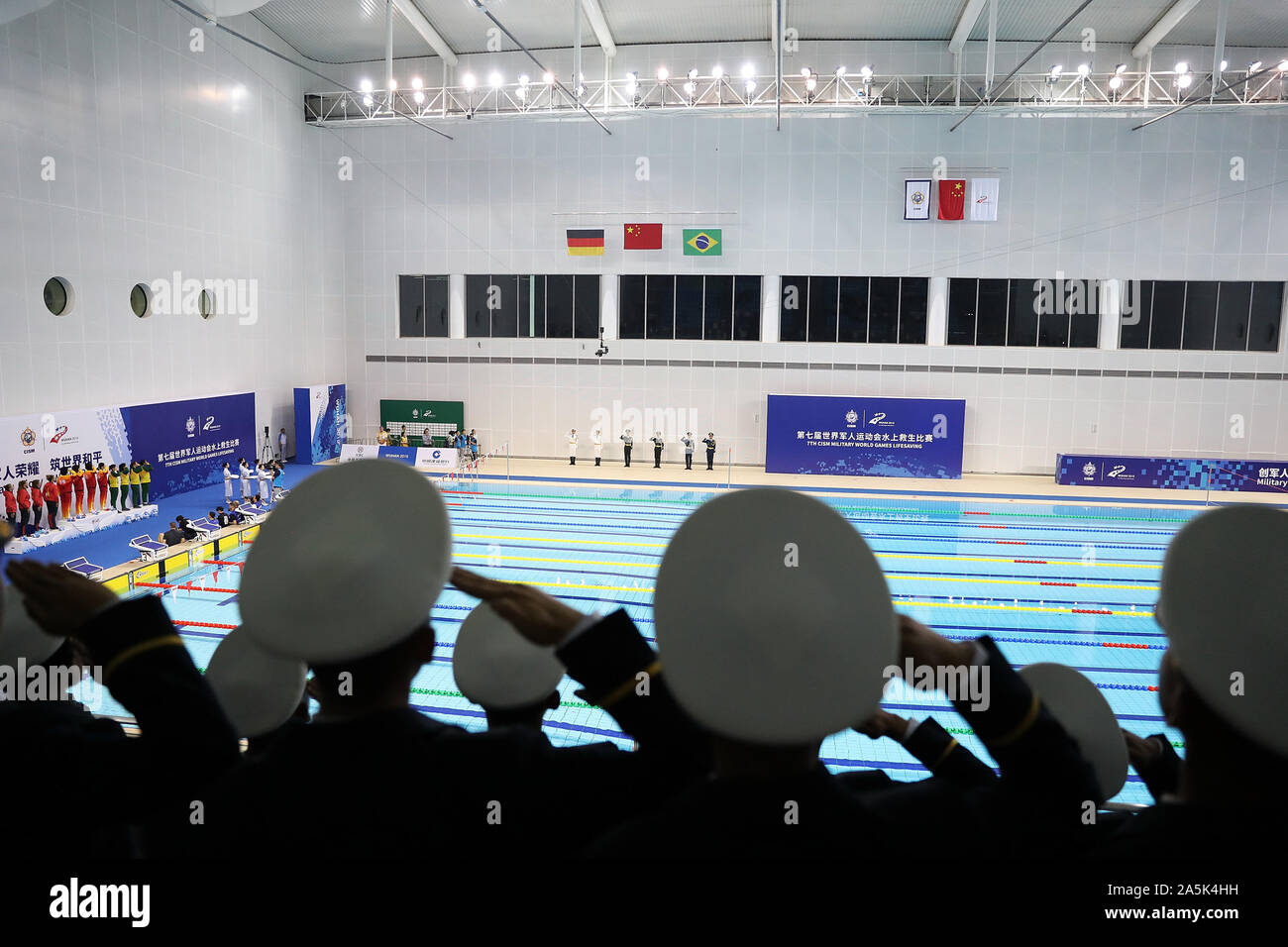 (191021) -- WUHAN, Oct. 21, 2019 (Xinhua) -- Soldiers salute during the awarding ceremony of women's 4x25m manikin relay of lifesaving at the 7th CISM Military World Games in Wuhan, capital of central China's Hubei Province, Oct. 21, 2019. (Xinhua/Wang Lili) Stock Photo