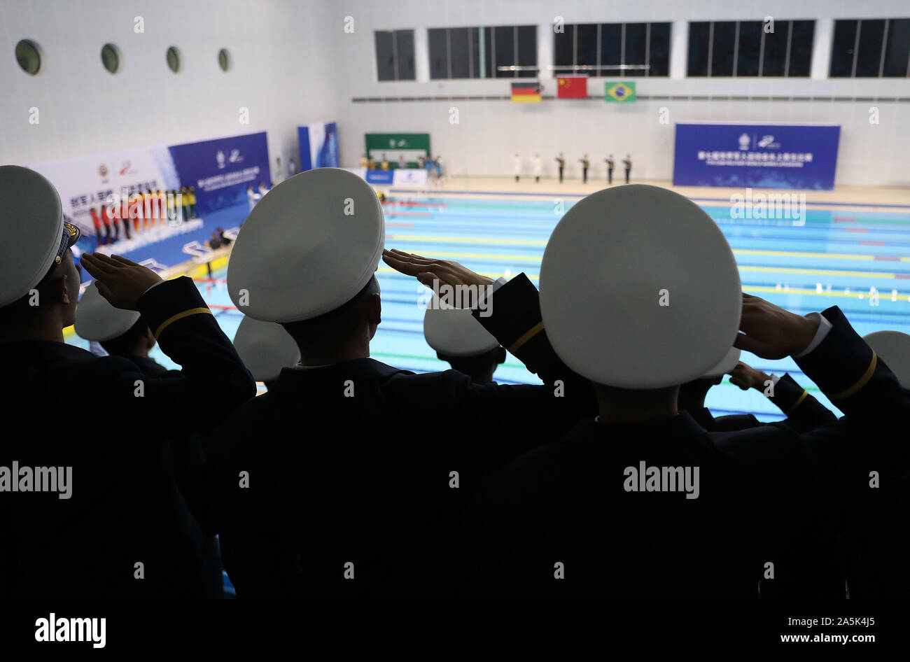 (191021) -- WUHAN, Oct. 21, 2019 (Xinhua) -- Soldiers salute during the awarding ceremony of women's 4x25m manikin relay of lifesaving at the 7th CISM Military World Games in Wuhan, capital of central China's Hubei Province, Oct. 21, 2019. (Xinhua/Wang Lili) Stock Photo