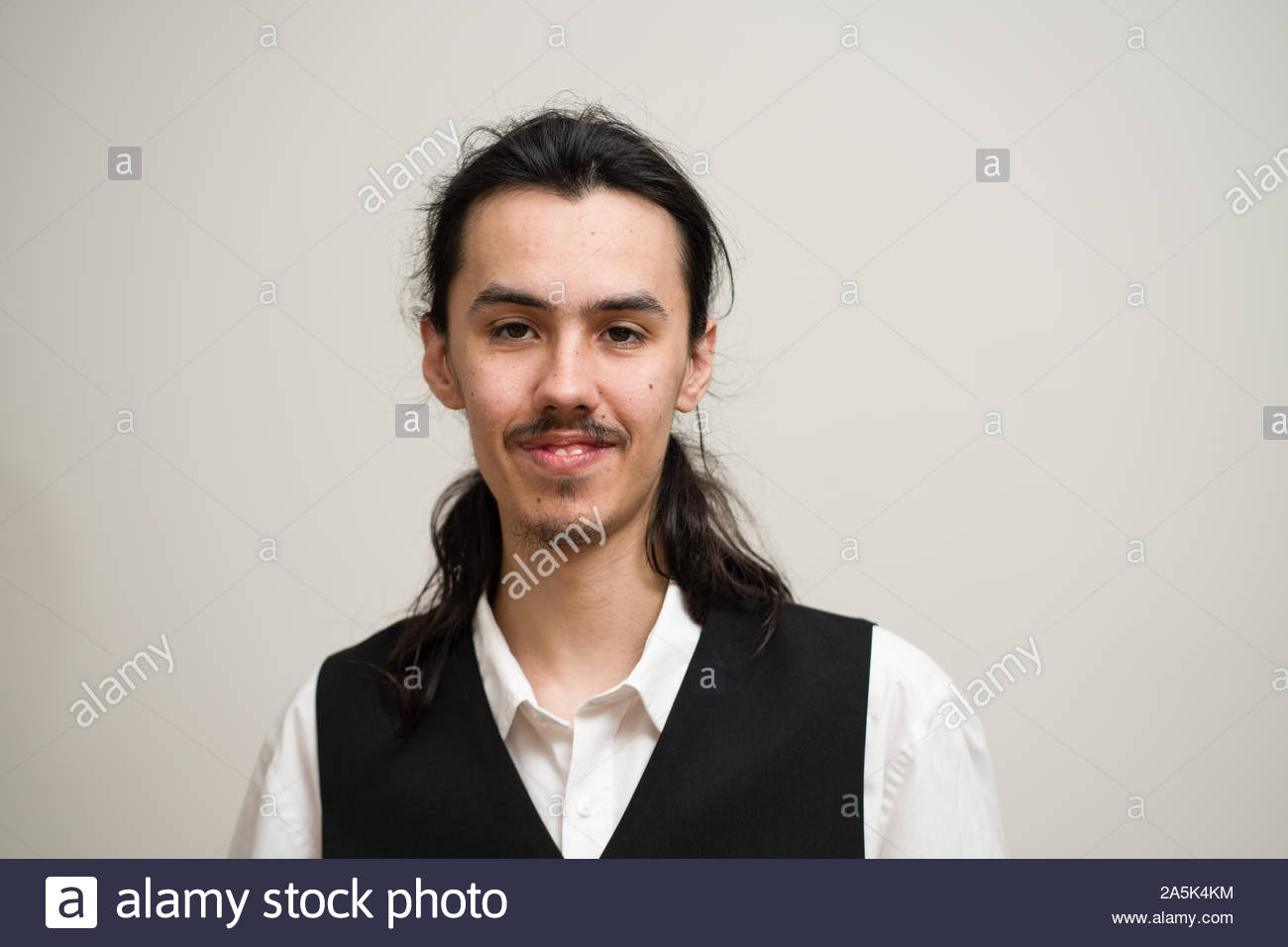 Long Haired Man With A Mustache And Ponytail Wearing A White