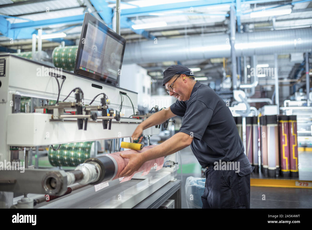 Working rolling on print surface in print factory Stock Photo