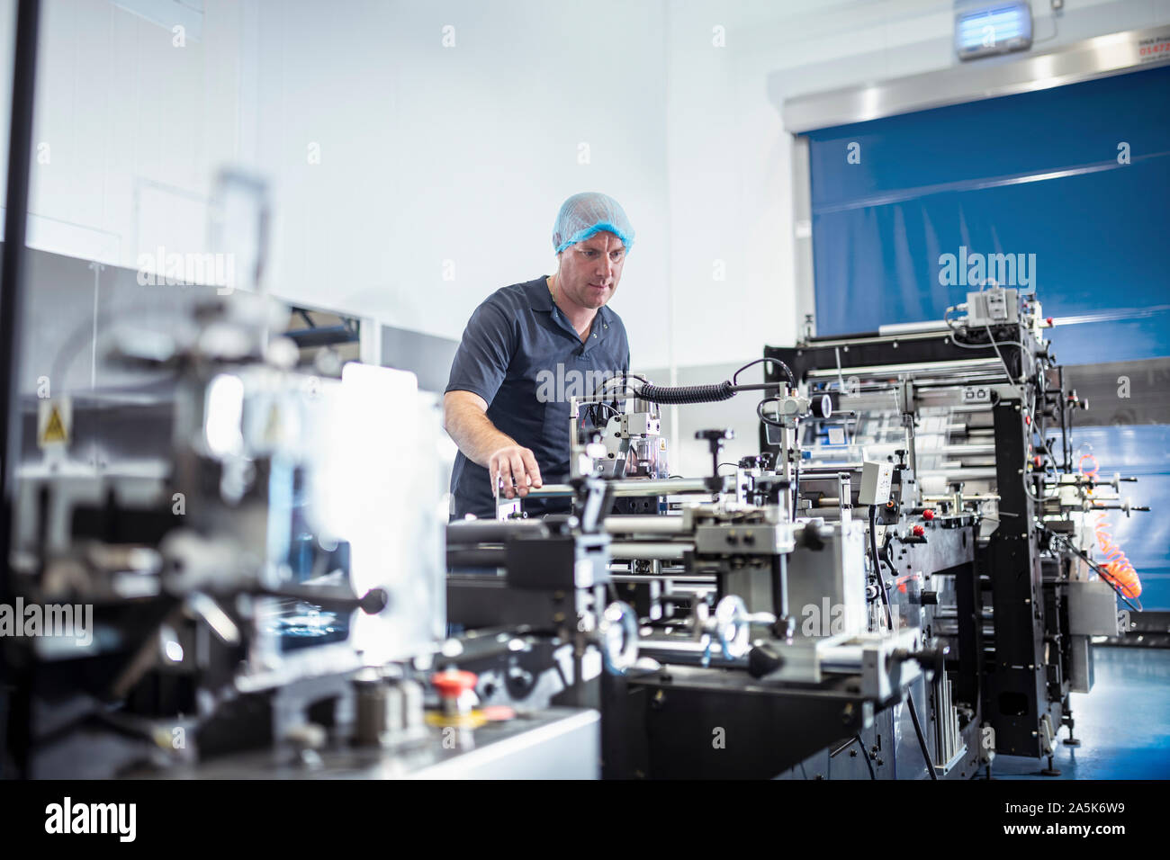 Worker With Food Packaging Machine In Print Factory Stock Photo Alamy