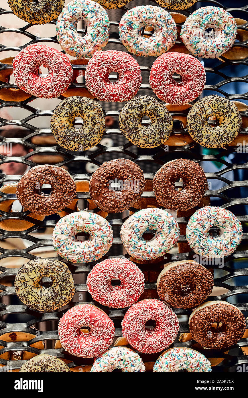 Colorful glazed donuts on a wire rack Stock Photo