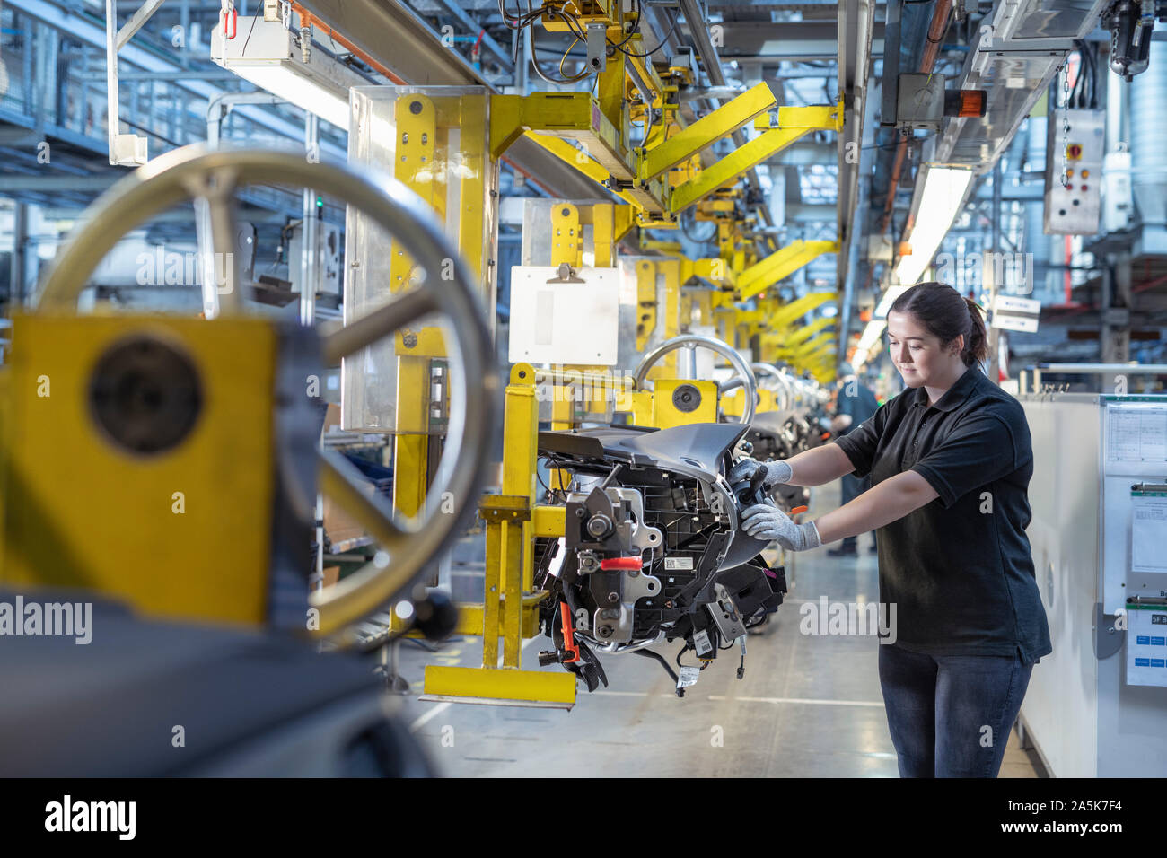 Female worker on dashboard assembly line in car factory Stock Photo