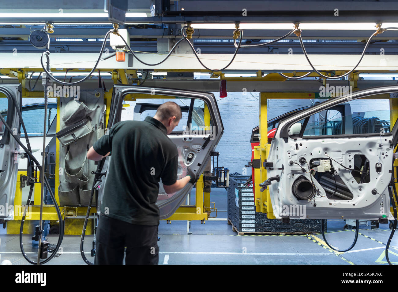 Worker on car door assembly line in car factory Stock Photo