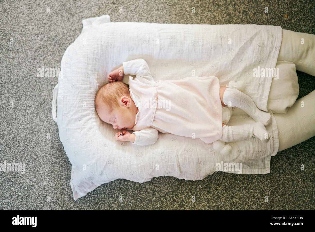 Baby sleeping on U-shaped pillow at home Stock Photo