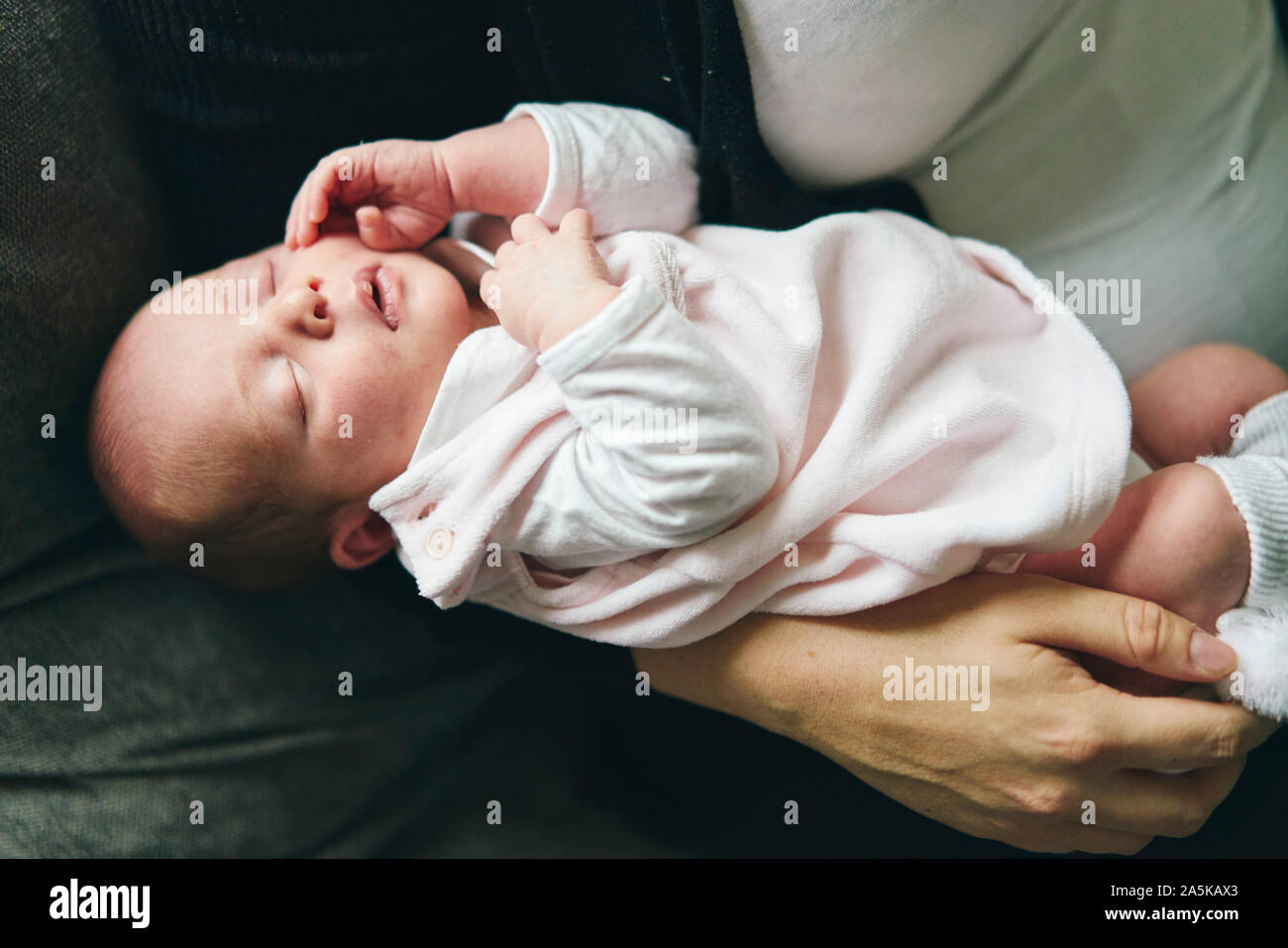 Mother cradling baby in arms Stock Photo Alamy