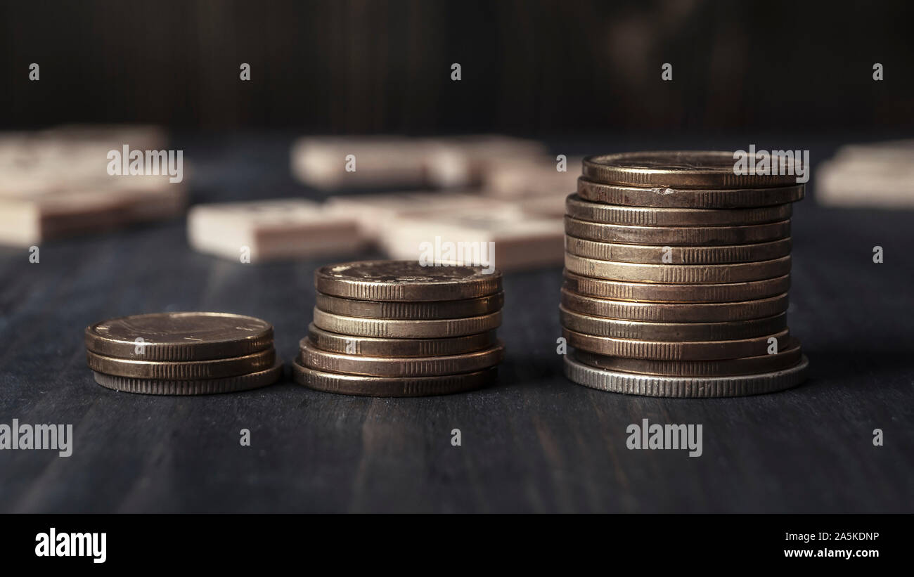 Stucks of coins on the wooden table, close up Stock Photo