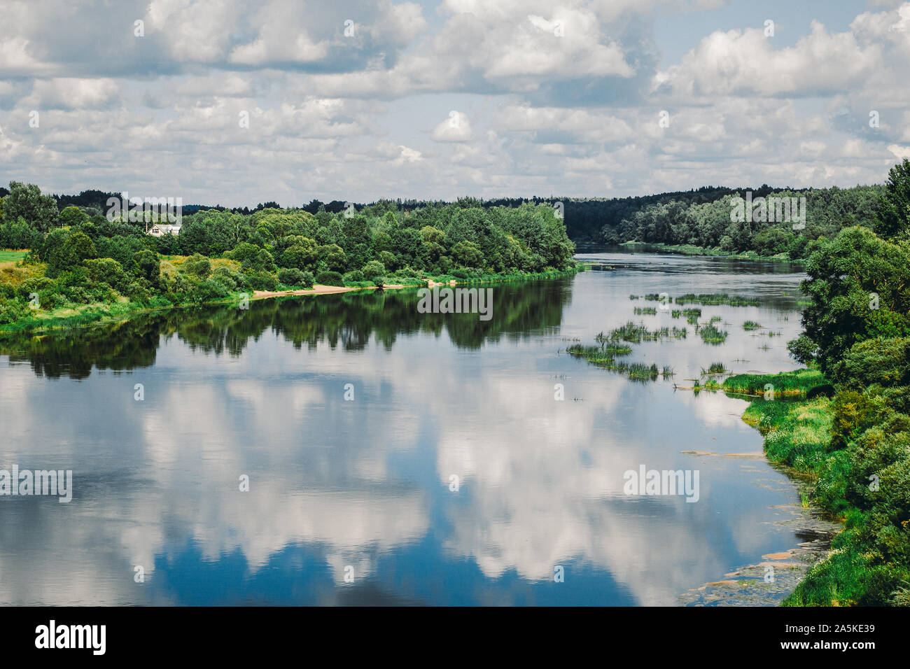 Summer landscape with river, cloudy sky, forest and sun Stock Photo - Alamy