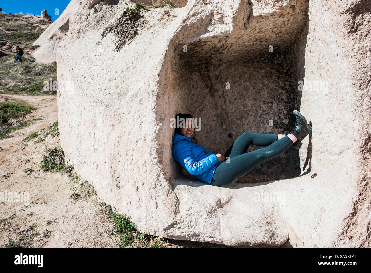 Woman lying down in cavern, Uchisar Castle, Göreme, Cappadocia, Nevsehir, Turkey Stock Photo
