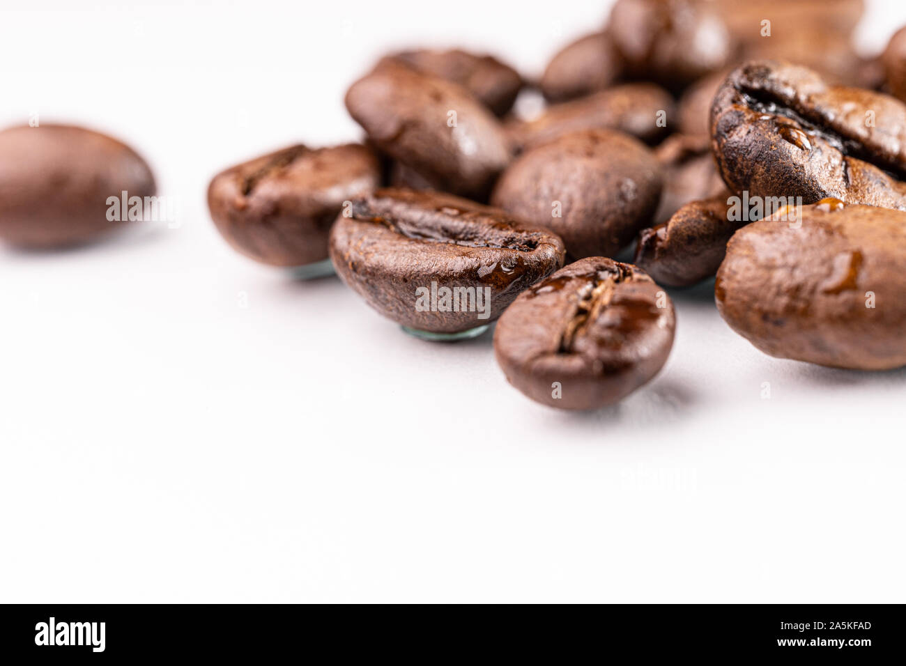 Brown roasted coffee beans on white background Stock Photo - Alamy