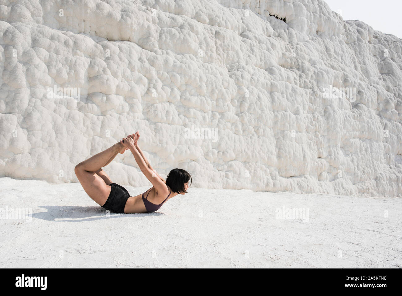 Woman practising yoga in cotton castle, Pamukkale, Denizli, Turkey Stock Photo