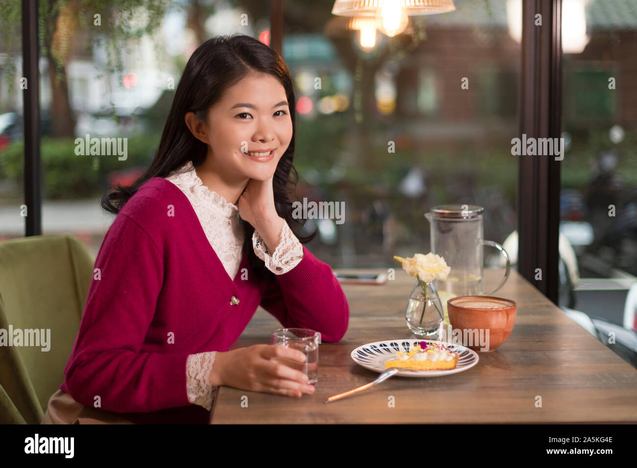 Woman sitting at table in cafe Stock Photo