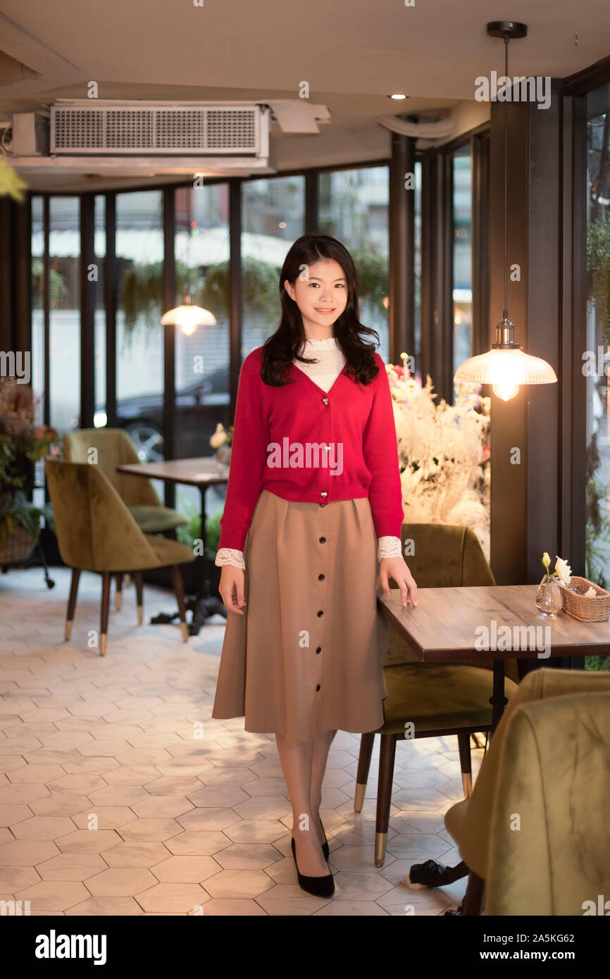 Woman standing next to table in restaurant Stock Photo