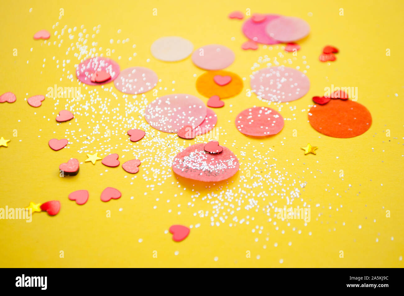 Colorful confetti, sparkles on bright yellow background. Festove background. Stock Photo