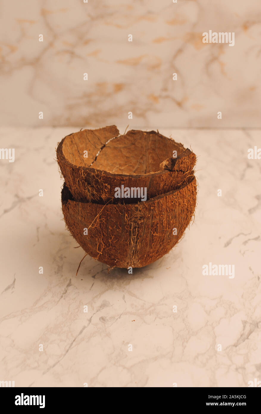 two halves of a coconut shell on a marble background, isolate. Future food bowls zero waste. Environmentally friendly material for utensils. Copy Stock Photo
