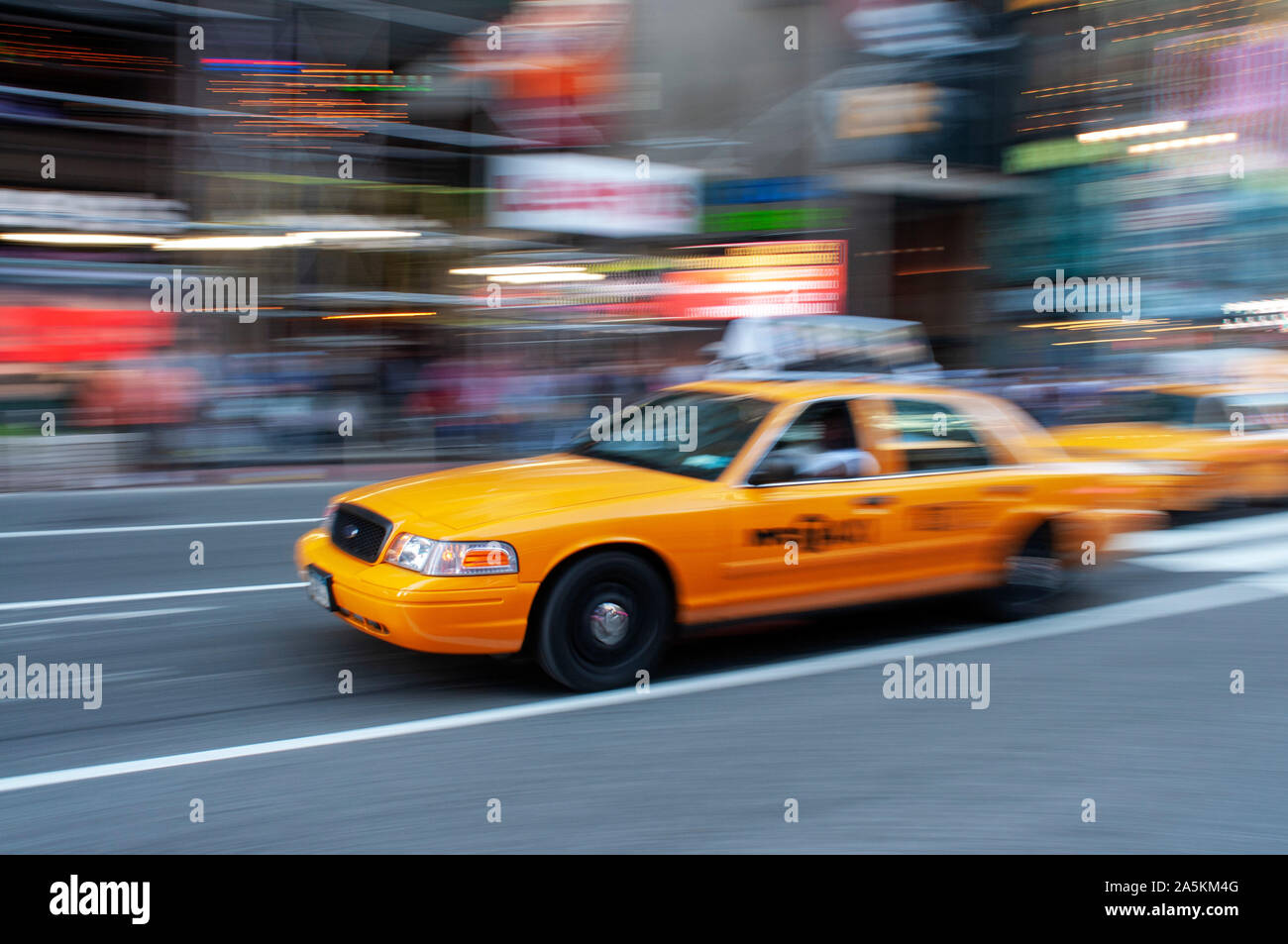 Yellow New York taxi cab driving fast on a street in New York City, USA