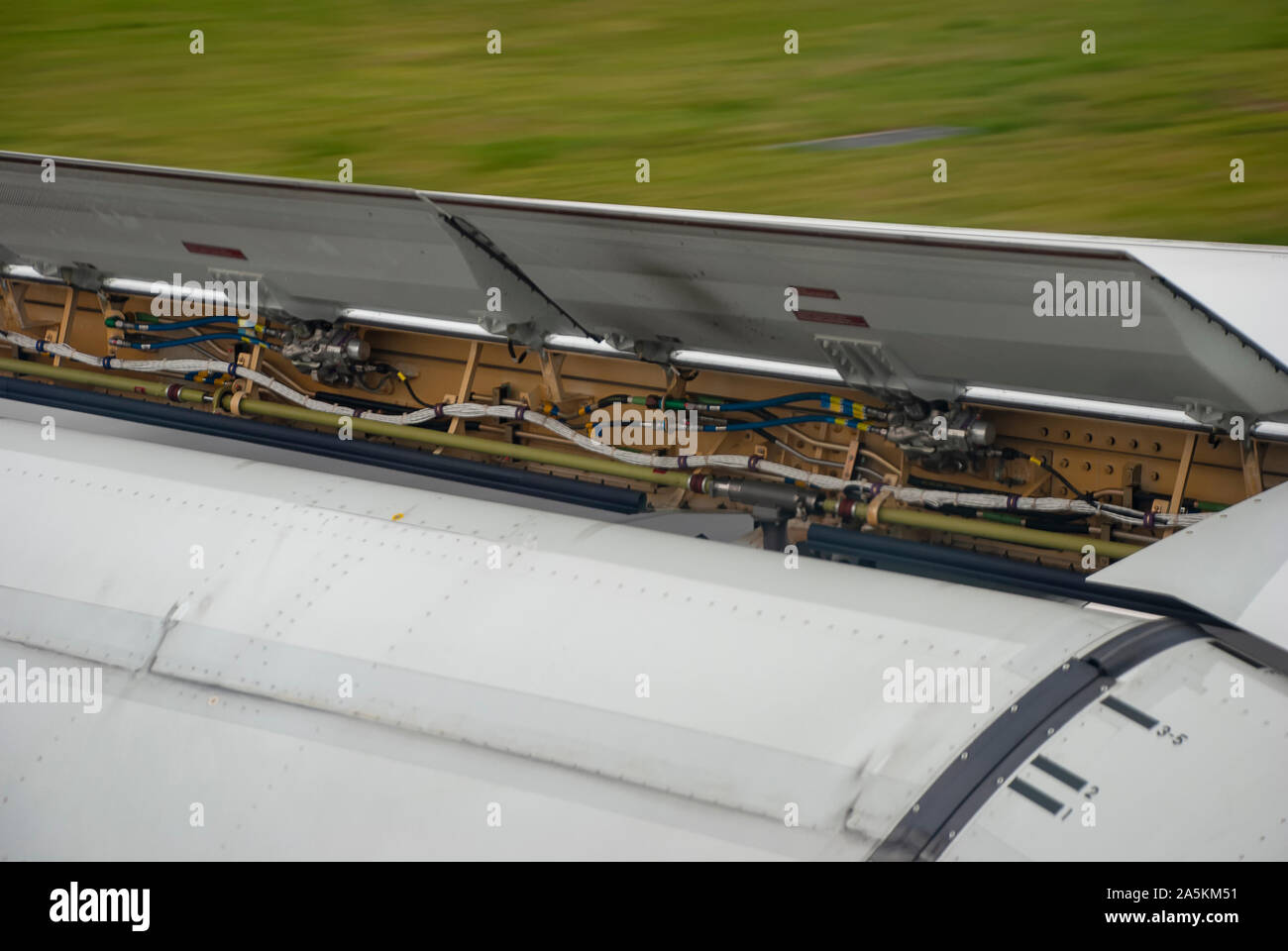 Air brakes and flaps on an aircraft wing as it slows after landing Stock Photo