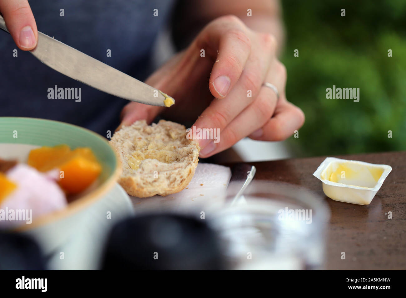 https://c8.alamy.com/comp/2A5KMNW/preparing-a-delicious-and-healthy-breakfast-in-this-photo-you-can-see-a-closeup-of-a-person-buttering-a-sandwich-roll-yummy!-2A5KMNW.jpg