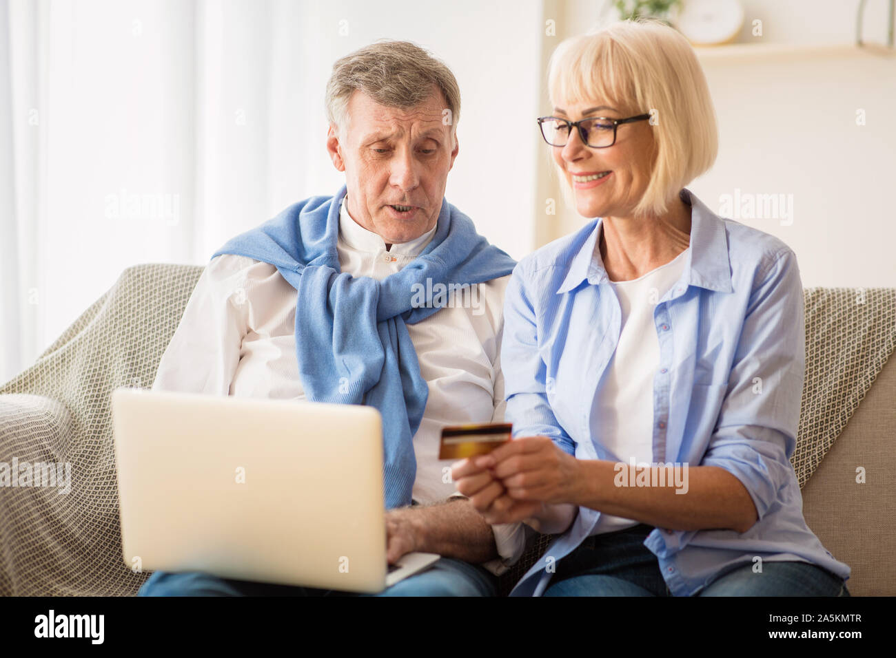 Mature couple shopping online in Internet, using laptop Stock Photo