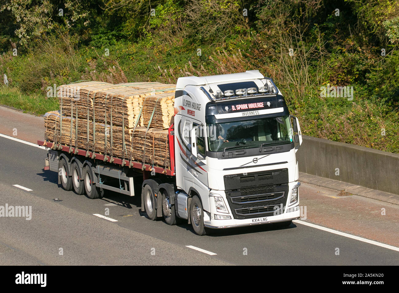D Spark Haulage (Inverness); wood products delivery trucks, timber lorry, transportation, truck, cut timber cargo, Volvo vehicle, delivery, commercial transport, industry, Scottish supply chain freight, on the M6 at Lancaster, UK Stock Photo