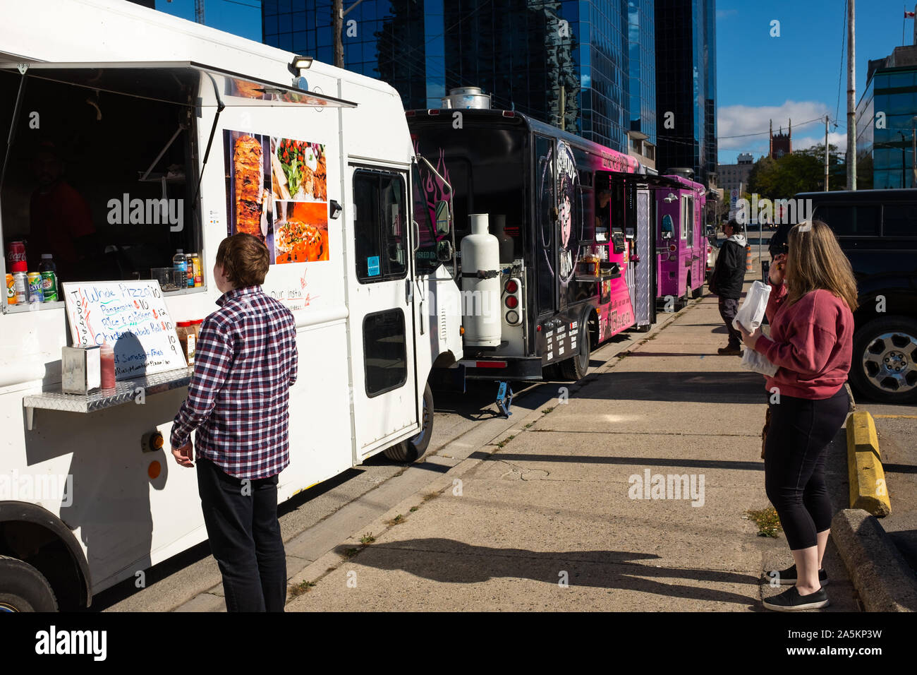 London, Canada - October 18, 2019. Lunch time patrons wait for their orders from food trucks setup in the city centre. Stock Photo