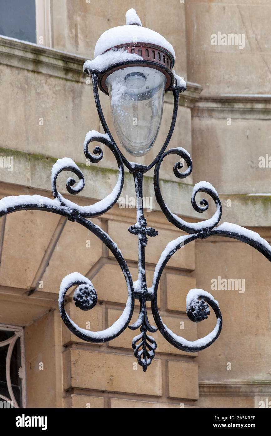 Ornate metal street lamp with snow on a street in Bath, England Stock Photo