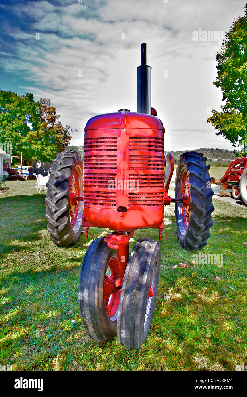 Red tractor sitting in a farmyard. Stock Photo