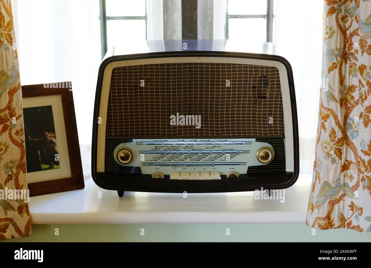 An old-fashioned radio resting on a window sill - John Gollop Stock Photo