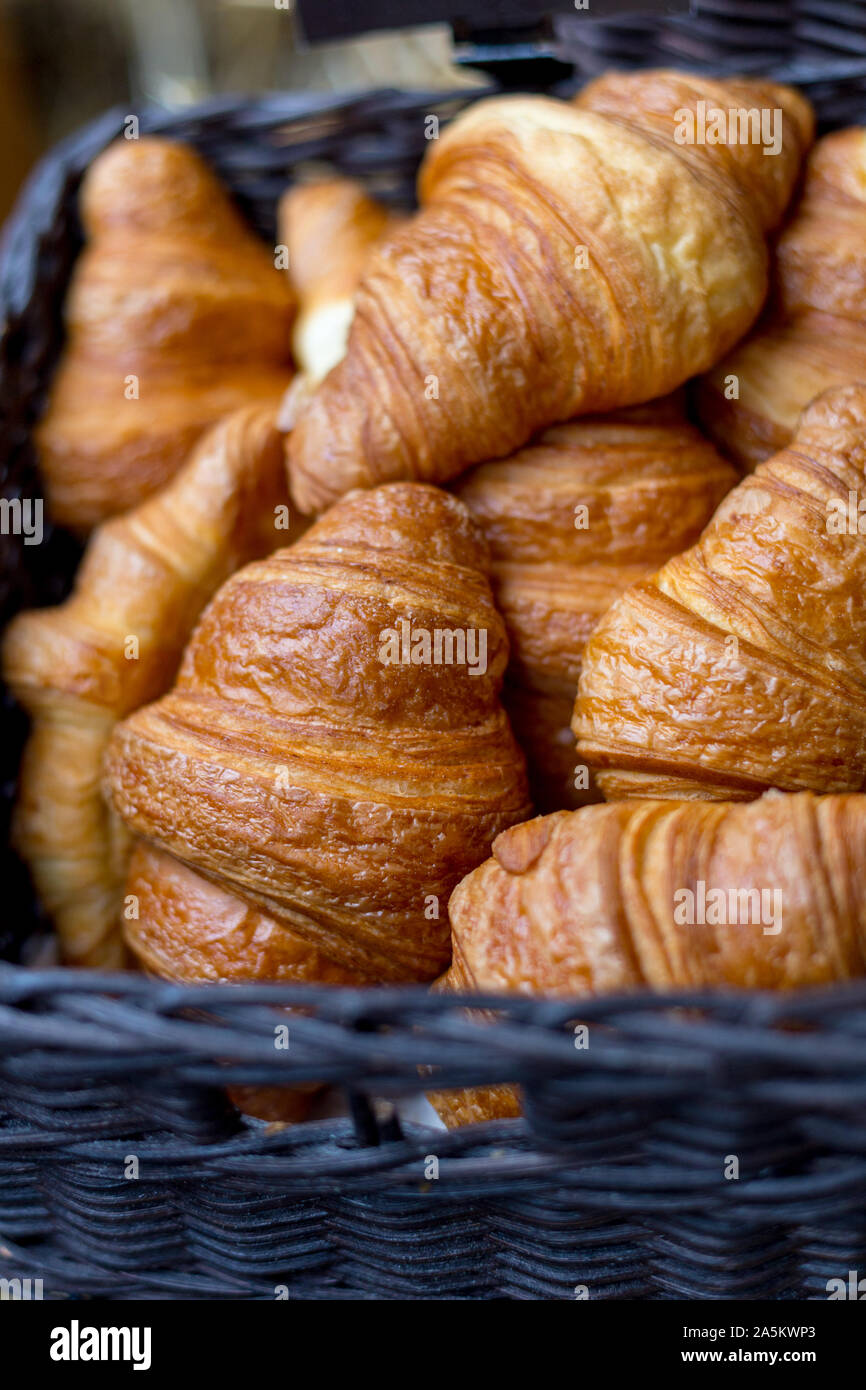 Croissants in a basket close-up on street food market. Concept of european traditional breakfast. Stock Photo