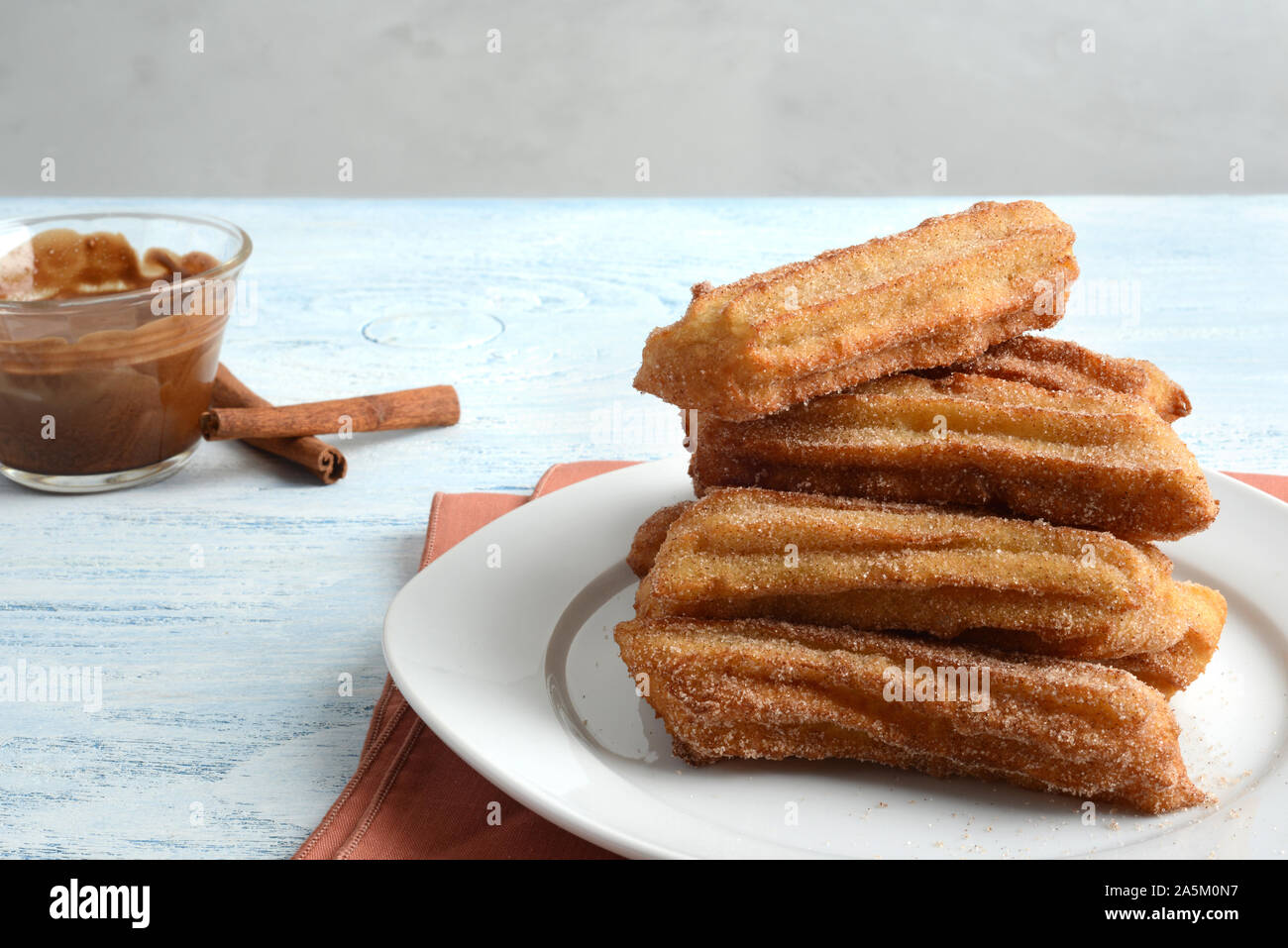 plate of churros with chocolate dipping sauce Stock Photo