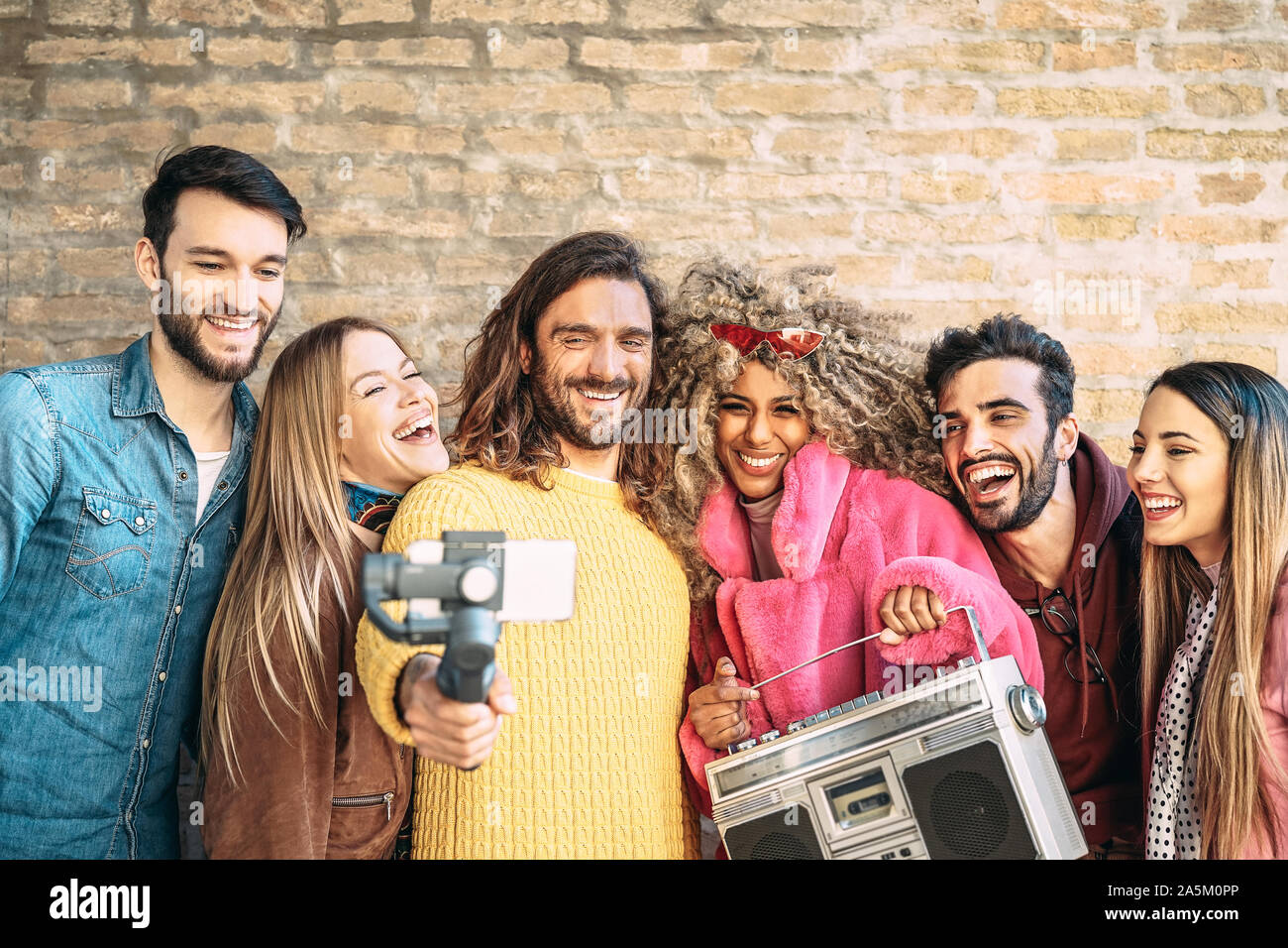Group of friends making video with gimbal mobile smartphone outdoor - Millennial young people having fun with new technology trendy apps Stock Photo