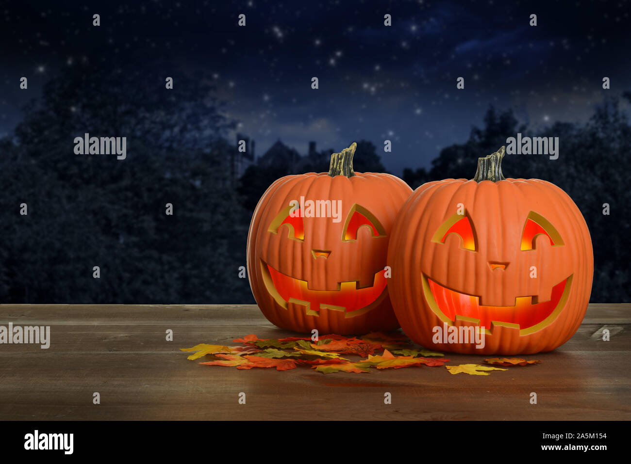 two halloween pumpkins at night glowing Stock Photo