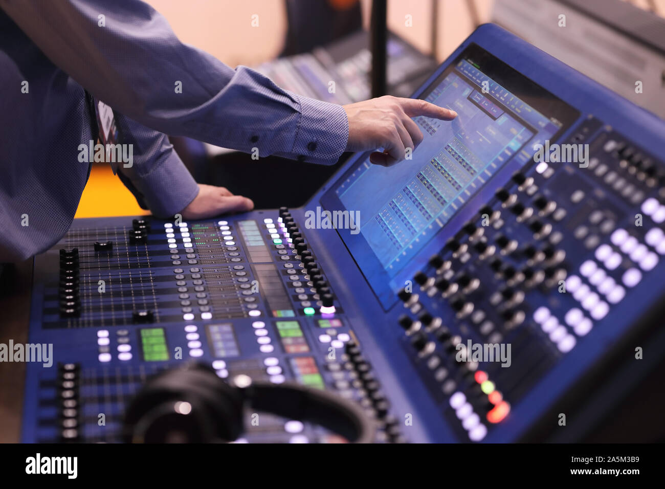 Operator working with digital mixing console using touch screen