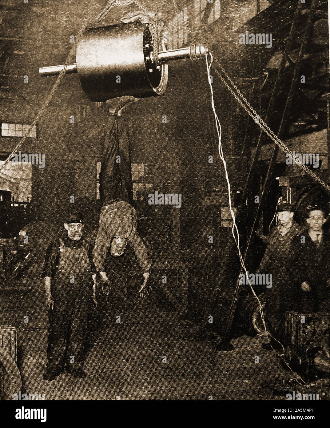 C1940's photograph of a man suspended from his metal soled  shoes by an electro magnet Stock Photo
