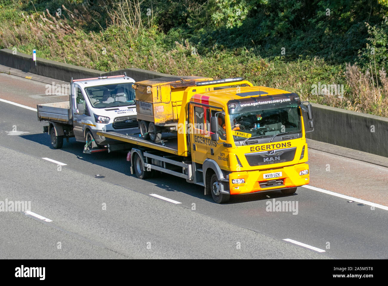 TWINKLE driving EGERTONS recovery Haulage delivery trucks, haulage, lorry, transportation, truck, cargo, MAN vehicle, delivery, transport, industry, supply chain freight, on the M6 at Lancaster, UK Stock Photo