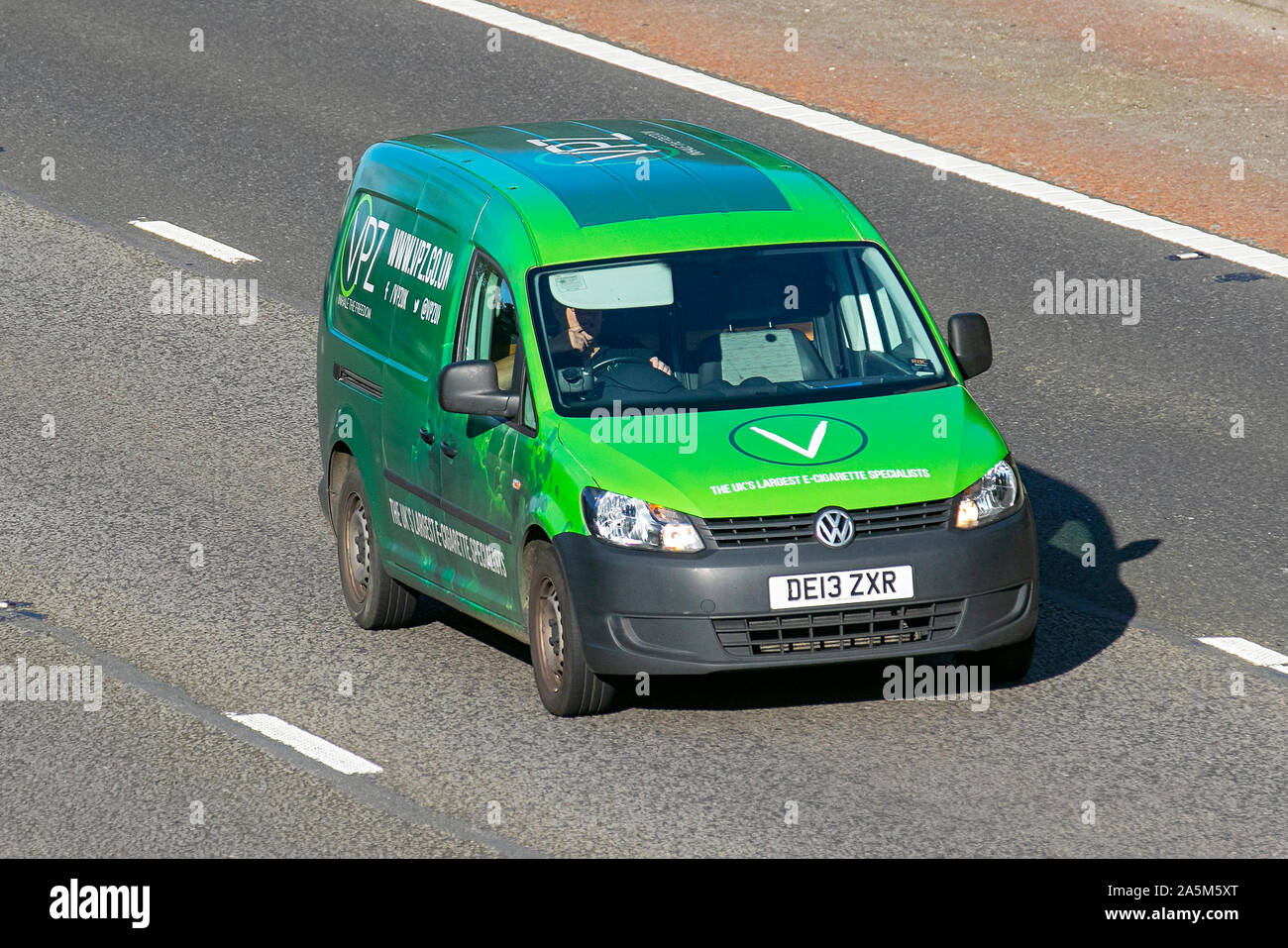 2013 green Volkswagen Caddy Maxi C20 TDI; UK VPZ 'The UK's largest e- cigarette specialists; Commercial vehicular traffic, transport, modern,  business van south-bound on the 3 lane M6 motorway highway Stock Photo -