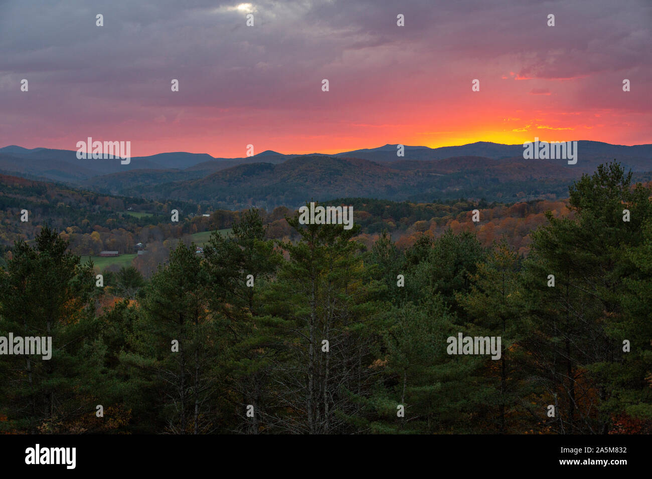 A dramatic fall sunset behind hills near Quechee, Vermont. Stock Photo