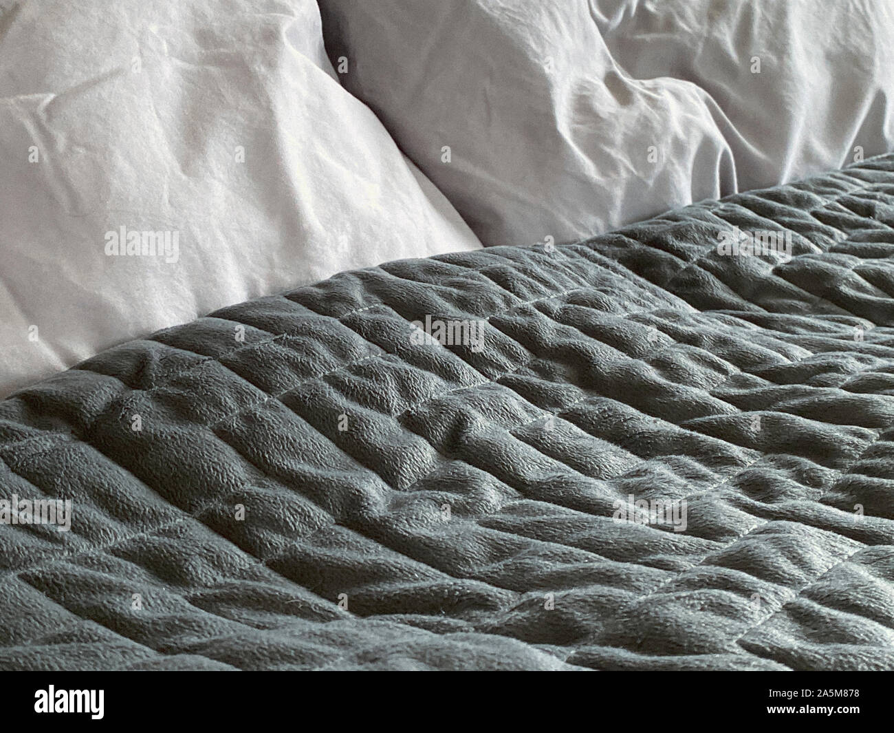 Still life of gray, weighted, blanket in bedroom Stock Photo