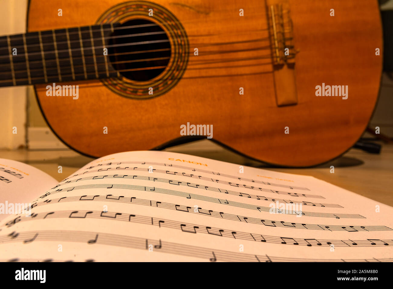 guitar standing behind musical notes Stock Photo
