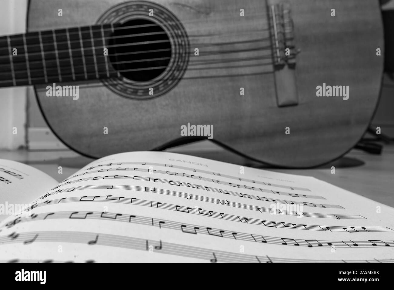 guitar standing behind musical notes Stock Photo