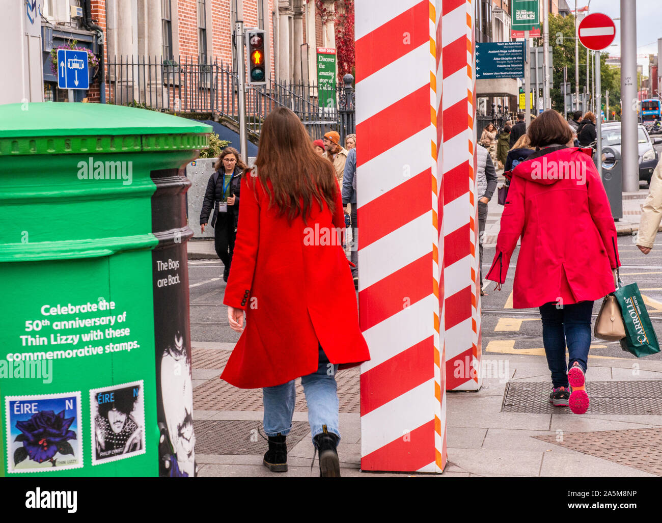 Pedestrians on busy walkway, green mailbox on pavement, Dublin, Ireland, UK Stock Photo