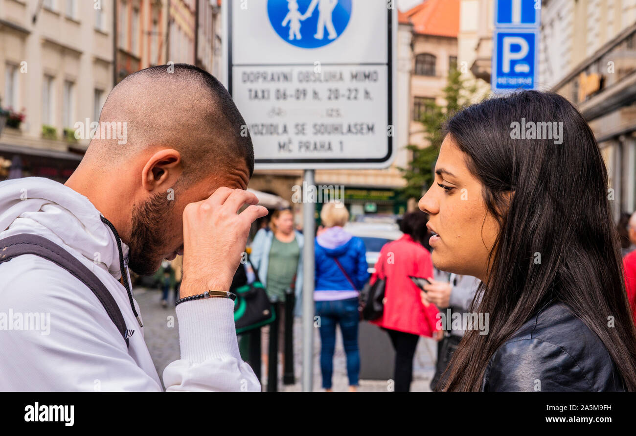Woman consoling upset friend on pavement, Prague, Czech Republic Stock Photo